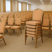 Konferenčná stolička s hnedým čalúnením a zlatým rámom.
