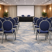 Konferenčná stolička s antracitovým rámom a modrým čalúnením.