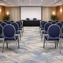 Konferenčná stolička s antracitovým rámom a modrým čalúnením.