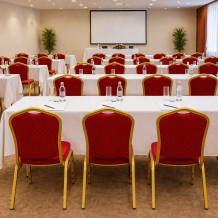 Konferenčná stolička s červeným čalúnením a zlatým rámom